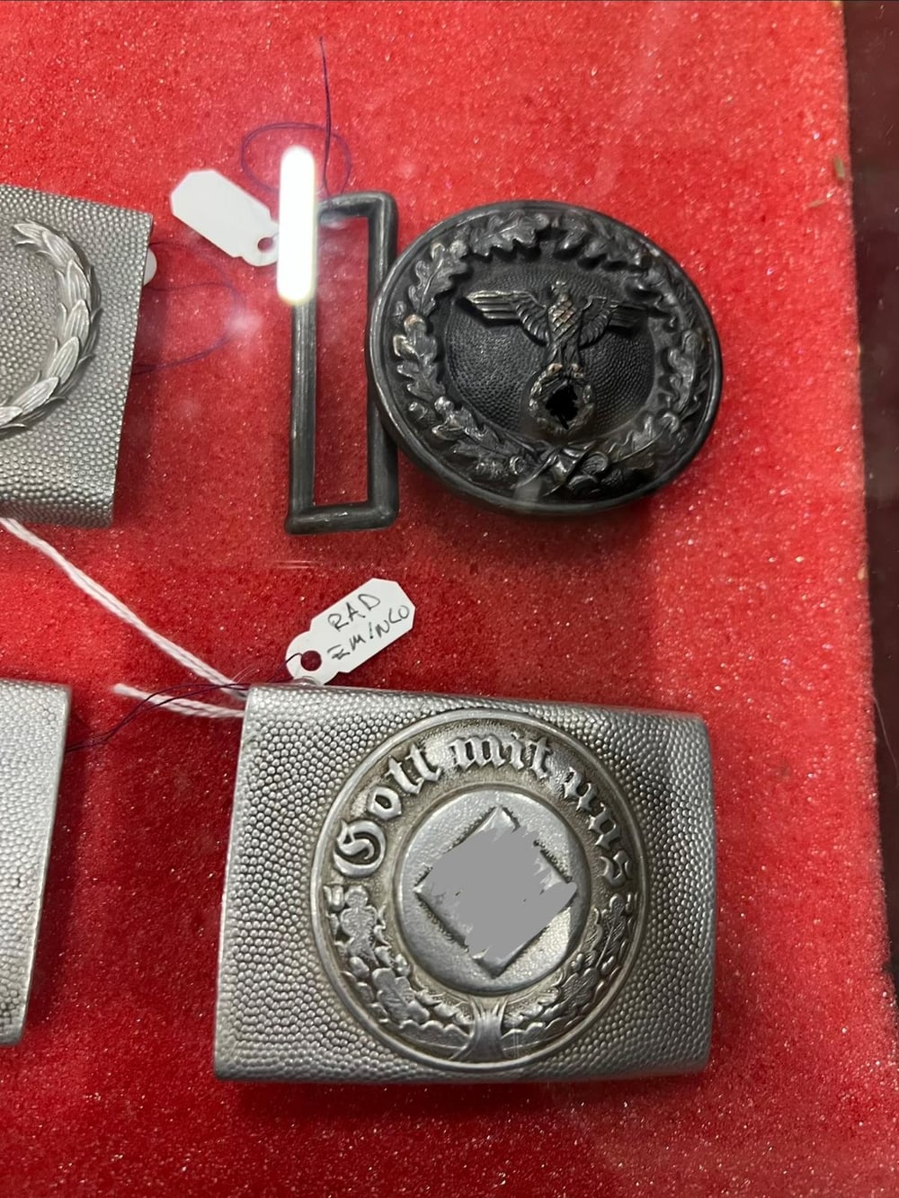 Koppelschlösser der Wehrmacht: das Mannschaftsschloss mit «Gott mit uns» und das runde Offiziersschloss mit Eichenlaubkranz. Symbole unkenntlich gemacht (§ 86a StGB).